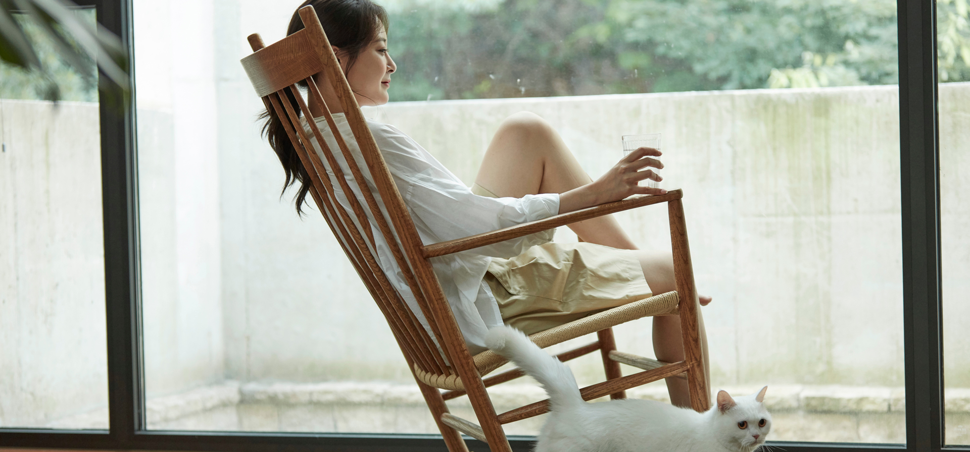 椅子にすわり窓の外を見ている女性